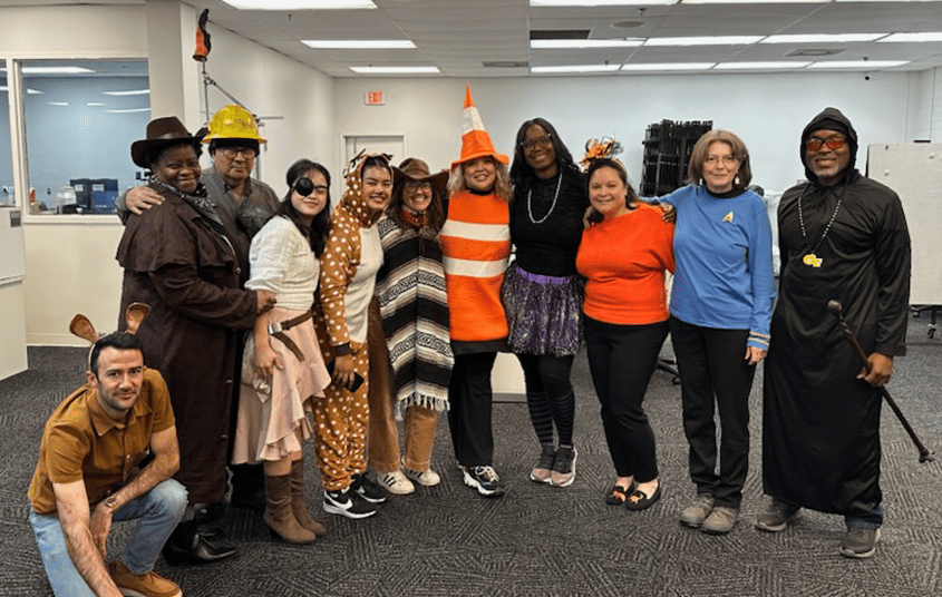 Group of Nexus Circular employees in Halloween costumes posing together in the office